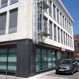 Escalera desplegable de escape en caso de incendio en la ventana de un edificio de oficinas bancarias equipado con un balcón de acceso.