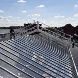 Maintenance walkway platform on rails used to clean windows on a factory glass roof.