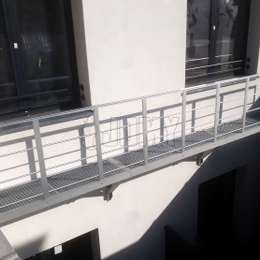 Aluminium walkway balcony mounted to the wall for fire escape purposes.