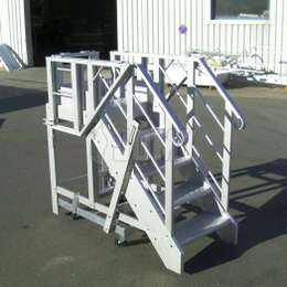 Mobile aluminium industrial platform and stairs with collapsible guardrails.